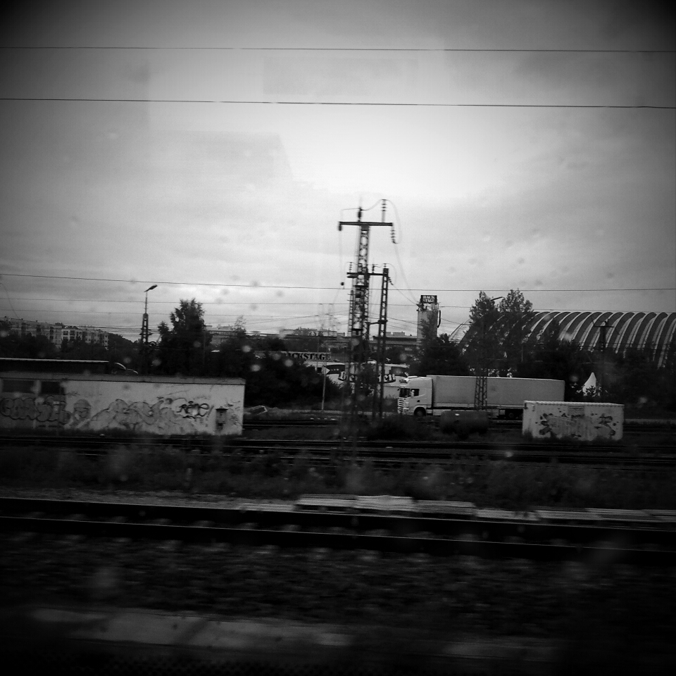 Black and white photograph of railway tracks, taped onto the notebook page